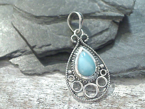 Larimar and sterling silver pendant measures around 1-1/2" tall with the bail by around 3/4" wide at the max points and is light weight. Use a thin gauge chain with this pendant. The color and pattern on the stone will vary slightly from the sample photos with each pendant.